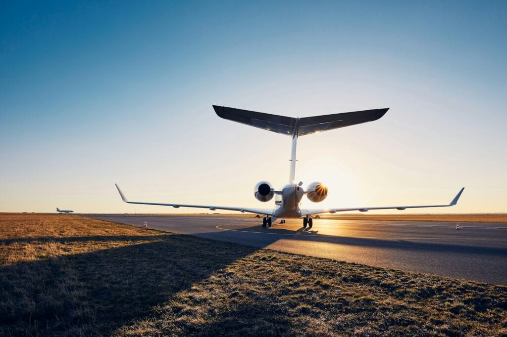 Airport at sunset. Silhouette of private jet against runway.